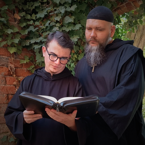 dwóch mężczyzn i kobieta zagłębieni w modlitwie